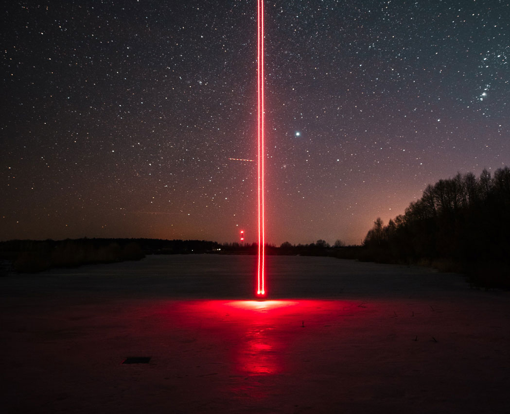 Rayo láser rojo de noche en el campo